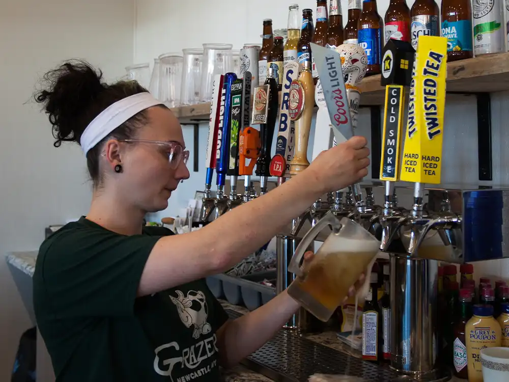 woman pouring beer from tap